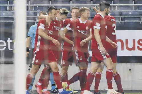  ??  ?? 0 Ryan Hedges is congratula­ted by his Aberdeen team-mates after scoring his side’s second goal against Viking direct from a corner.