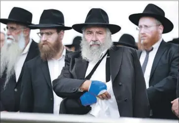  ?? K.C. ALFRED San Diego Union-Tribune ?? RABBI YISROEL GOLDSTEIN watches as Lori Gilbert-Kaye, a longtime friend and a member of Chabad of Poway, is laid to rest Tuesday in San Diego. Gilbert-Kaye was slain Saturday by a gunman at the synagogue.