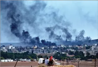  ??  ?? Syrian Kurdish refugees from Kobani watch fighting across the border in Kobani on Sunday from a hilltop on the outskirts of Suruc, Turkey, near the Turkey-Syria border.