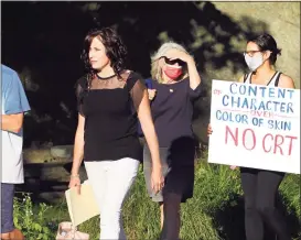  ?? Christian Abraham / Hearst Connecticu­t Media ?? A woman carrying a sign protesting the teaching of critical race theory arrives at a Board of Education meeting at Central Middle School in Greenwich in June.