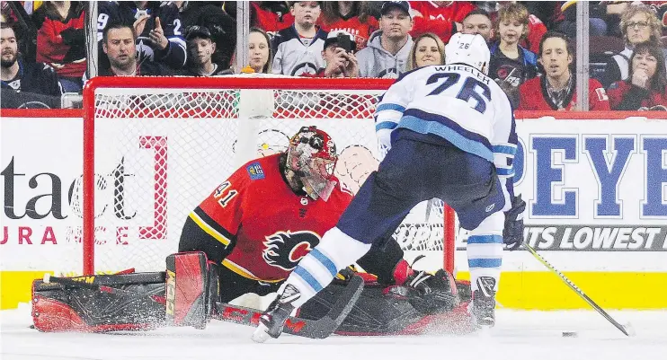  ?? — GETTY IMAGES ?? Winnipeg’s Blake Wheeler scores against Flames netminder Mike Smith during Saturday’s shootout at Scotiabank Saddledome in Calgary.