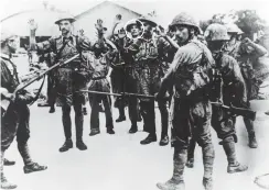  ??  ?? Singapore surrender: The British soldiers facing the bayonets of Japanese soldiers in this famous photograph include David Moffat (left, with moustache) and Frank Baker (circled)