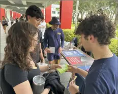  ?? Cody Jackson/Associated Press ?? College students pass out materials to educate young voters Thursday at Florida Atlantic University in Boca Raton, Fla. Abortion and marijuana will be on Florida’s November ballot, and these issues are critical issues for young voters.