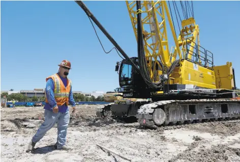  ?? Joe Raedle / Getty Images ?? Michael Smith works at a Miami job site. Constructi­on picked up as weather improved last month, and builders hired 45,000 people.