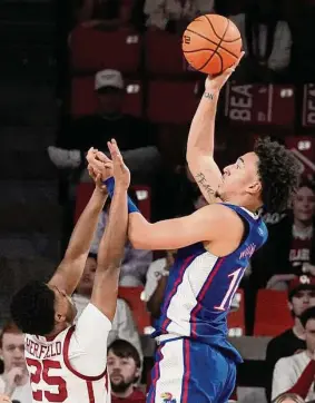  ?? Sue Ogrocki/Associated Press ?? Kansas forward Jalen Wilson shoots over Oklahoma’ Grant Sherfield during Saturday’s game in Norman, Okla. Wilson scored 18 points in the Jayhawks’ win.