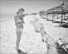  ?? Jeff J Mitchell
Getty Images ?? AT THE BEACH near the Imperial Marhaba hotel, a woman brings f lowers to a memorial. A gunman killed at least 38 people, nearly two-thirds from Britain.