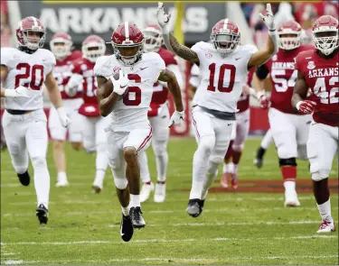  ?? MICHAEL WOODS — THE ASSOCIATED PRESS ?? Alabama punt returner DeVonta Smith, middle, returns a punt for a touchdown against Arkansas during Saturday’s win.