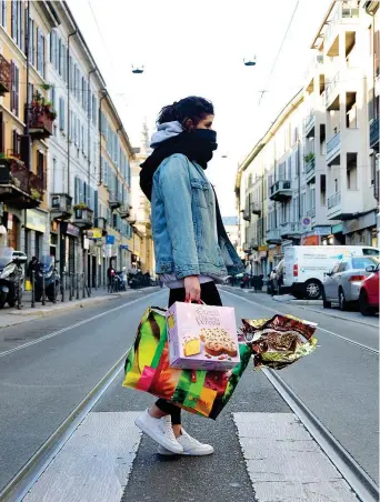  ??  ?? Sola
Una giovane donna uscita per fare la spesa ieri per le vie di Milano