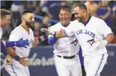  ?? Nathan Denette / Associated Press ?? The Blue Jays’ Kendrys Morales (right) celebrates with teammates after hitting a gameending solo homer off Santiago Casilla.