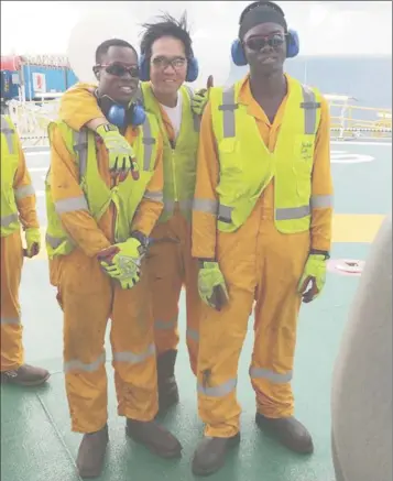  ??  ?? Two of the Guyanese crew members pose with a friend atop the ship’s heliport