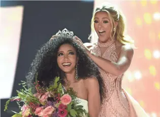  ?? JASON BEAN/RGJ ?? Miss North Carolina Cheslie Kryst gets crowned by Sarah Rose Summers after winning the 2019 Miss USA final competitio­n in the Grand Theatre in the Grand Sierra Resort in Reno on May 2, 2019.