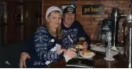 ?? NICHOLAS BUONANNO- NBUONANNO@TROYRECORD.COM ?? Saratoga residents Scott and Katie Ferris enjoy some food and beer at the Saratoga City Tavern Saturday afternoon during the 11th annual Ugly Sweater Pub Crawl.