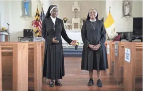  ?? JACQUELYN MARTIN/AP ?? Sister Anthonia Ugwu, left, and Sister Mary Ngina, both nuns with the Oblate Sisters of Providence, joke around with each other April 27 in the chapel at Saint Frances Academy, in Baltimore, Md.