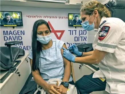  ?? Photo: AP ?? A medic from Israel’s Magen David Adom emergency service administer­s a booster shot of the coronaviru­s vaccine to a woman in Tel Aviv, Israel, on August 14, 2021.