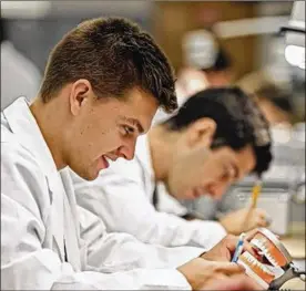  ?? KYLE ROBERTSON / COLUMBUS DISPATCH ?? Elisha Strahler, of Waterford, works in a lab at Ohio State’s College of Dentistry. Strahler is involved in a new program training dental students in underserve­d areas. He plans to practice in southeaste­rn Ohio.