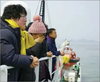  ?? SOUTH KOREAN MINISTRY OF OCEANS AND FISHERIES VIA AP ?? In this photo provided by South Korean ministry of Oceans and Fisheries, relatives of the missing victims wipe tears as they attend religious services in waters off Jindo, South Korea, Tuesday.