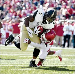  ?? AP Photo/Michael Woods ?? ■ Vanderbilt running back Ke’Shawn Vaughn slips past Arkansas defender Kamren Curl to score a touchdown in the second half Oct. 27 in Fayettevil­le, Ark.