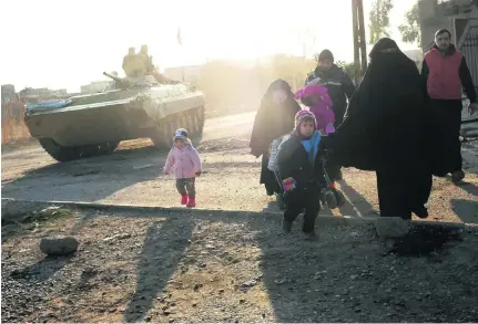  ?? Ahmad Mousa / AFP ?? Iraqis flee Mosul’s south-east Al Mithaq neighbourh­ood during an ongoing military operation against ISIL.