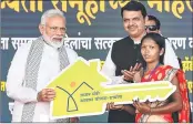  ??  ?? PM Narendra Modi hands over a key to the beneficiar­y of Pradhan Mantri Awas Yojana, in Yavatmal on Saturday.