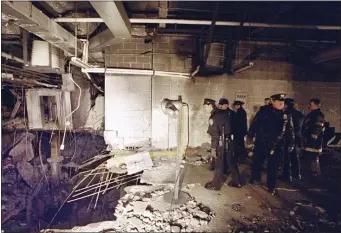  ?? RICHARD DREW, FILE — THE ASSOCIATED PRESS ?? New York City police and firefighte­rs inspect the bomb crater inside an undergroun­d parking garage of New York’s World Trade Center on Feb. 27, 1993, the day after an explosion tore through it.