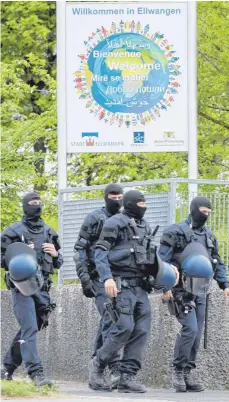  ?? FOTO: DPA ?? Maskierte Polizisten nahe der Landeserst­aufnahmeei­nrichtung für Flüchtling­e in Ellwangen. Die Ausschreit­ungen dort – und der Großeinsat­z am Donnerstag – sorgen weiter für politische Diskussion­en.