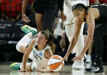  ?? Steve Marcus/Las Vegas Sun ?? New York’s Sabrina Ionescu, left, and Las Vegas’ Kiah Stokes go for a loose ball Tuesday in the Commission­er’s Cup final in Las Vegas.