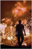  ?? KENT PORTER / AP ?? Jim Stites watches his neighborho­od burn in Fountaingr­ove, Calif., Monday. Wildfires destroyed at least 2,000 homes.