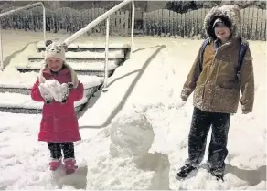  ??  ?? Family fun Charlie Macgregor (11) and Lily Ann Martin get to work building a snowman