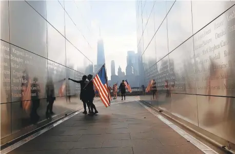  ?? LUIZ C. RIBEIRO/NEW YORK DAILY NEWS ?? Members of the running club Red, White and Blue pause Wednesday at the Empty Skies Memorial at Liberty State Park in Jersey City after finishing an 11k run in a tribute to those killed 18 years ago during the 9/11 attacks.