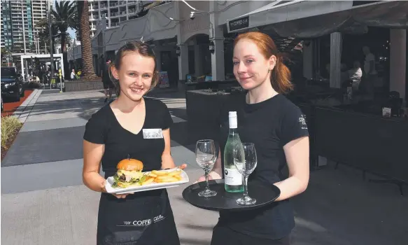  ??  ?? Coffee Club workers Chloe Stephens and Freyja Hagen on the new-look Surf Parade following a $5 million renovation. Picture: STEVE HOLLAND