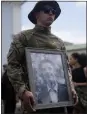  ?? ?? A soldier holds a picture of activist and soldier Roman Ratushnyi during Saturday’s memorial service.