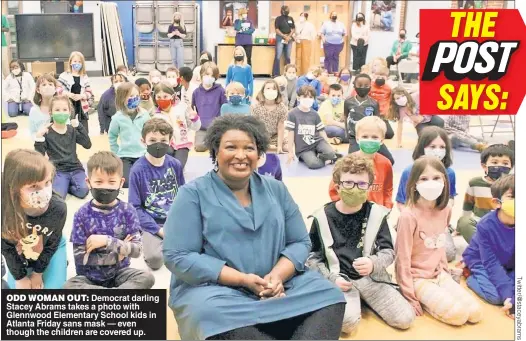  ?? ?? ODD WOMAN OUT: Democrat darling Stacey Abrams takes a photo with Glennwood Elementary School kids in Atlanta Friday sans mask — even though the children are covered up.