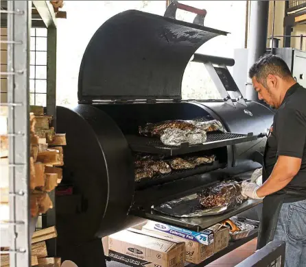  ?? — Photos: YAP CHEE HONG/The Star ?? Nazri and his team tend to the meat in the smoker from 8pm to 8am, checking it constantly to make sure the temperatur­e is right.