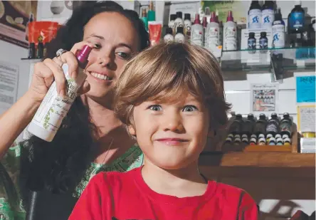  ?? Picture: SCOTT FLETCHER ?? Aimee Williams, who has created an all-natural spray that repels nits, tries it on Zane Books, 5.