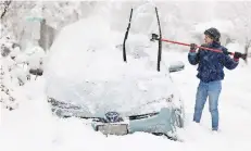  ?? ?? Cathy MORGANMace retira el hielo del auto de su familia, en Salt Lake City, Utah