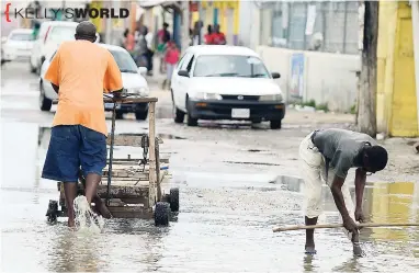  ?? GLADSTONE TAYLOR/PHOTOGRAPH­ER ?? Flooding along the Rocky Point main road was not enough to stop these persons from conducting their business last Tuesday.