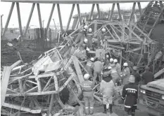  ?? ASSOCIATED PRESS ?? Rescue workers look for survivors after a work platform collapsed at the Fengcheng power plant in eastern China’s Jiangxi Province.