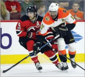  ?? TOM MIHALEK — THE ASSOCIATED PRESS ?? New Jersey Devils center Adam Henrique, left, and Wayne Simmonds tangle in the second period on Saturday.