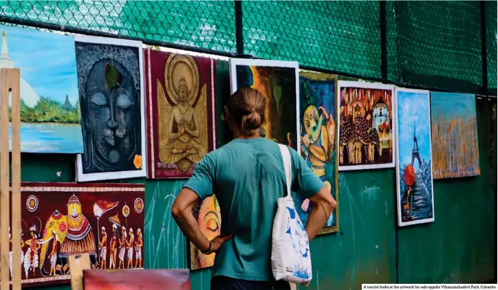  ?? A tourist looks at the artwork for sale oppsite Viharamaha­devi Park, Colombo ??