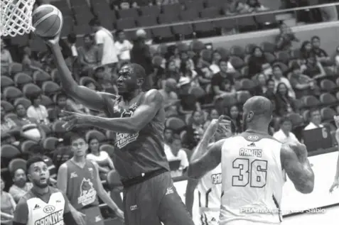  ?? (PBA PHOTO) ?? Barako Bull Energy Cola import Solomon Alabi shoots as Kia Carnival’s PJ Ramos looks on during their game in the PBA Commission­er’s Cup yesterday at the Smart Araneta Coliseum. Energy won 95-86.