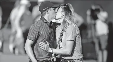  ?? THE ASSOCIATED PRESS] [ERIC CHRISTIAN SMITH/ ?? Carlos Ortiz, left, kisses wife, Haley Ortiz, after winning the Houston Open Sunday in Houston.