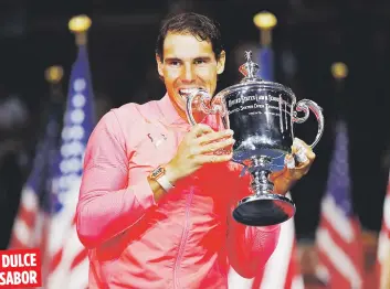  ??  ?? El español Rafael Nadal muerde el trofeo de campeón luego de su triunfo en el final del US Open sobre el sudafrican­o Kevin Anderson en tres parciales.