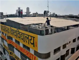  ?? — PTI ?? Workers partially demolish the spiritual university at Rohini on Tuesday from where many girls were rescued recently. The ashram was taken to task for violating civic norms.