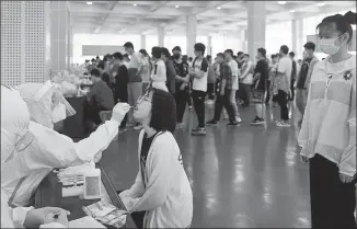  ?? CHEN LI / FOR CHINA DAILY ?? Students at a middle school in Lu’an, Anhui province, undergo nucleic acid testing on Friday.