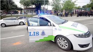  ?? — Bernama photo ?? Police personnel are seen controllin­g the situation at the site.