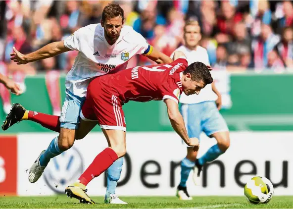  ?? AFP ?? That’s mine: Chemnitz defender Marc Endres (left) vying for the ball with Bayern Munich striker Robert Lewandowsk­i in the German Cup first-round match on Saturday. Bayern won 5- 0. —