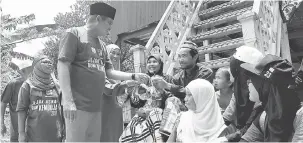  ?? — Gambar Bernama ?? AGIH: Mohamad Ali mengagihka­n daging korban kepada keluarga masyarakat Islam Kemboja sempena Hari Raya Aidiladha pada program ‘Jejak Asnaf@Korban di Bumi Kemboja’, semalam.