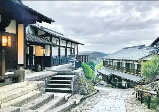  ?? Charles Fleming ?? NIGHT FALLS in Magome, Japan, a picturesqu­e stopping point for travelers along the Nakasendo Way, with restaurant­s and shops selling crafts made from cedar.