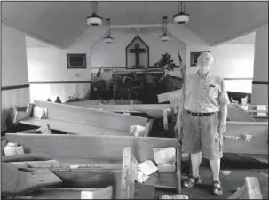  ?? The Associated Press ?? FLOOD DAMAGE: Pastor Floyd Benfield stands in front of the flood-damaged sanctuary of the Presbyteri­an Church of the Covenant on Thursday in Spring Lake, N.C. Just days before, the flooding Little River had left the church half submerged.