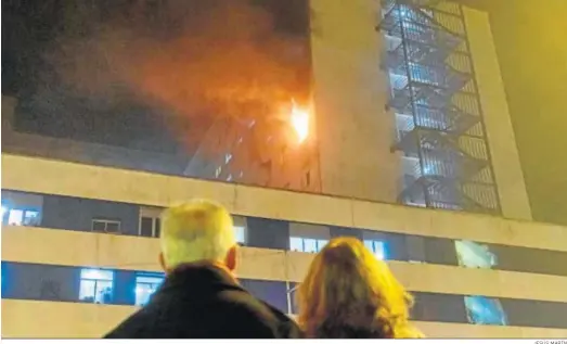  ?? JESÚS MARÍN ?? Una pareja observando el fuego que sale de la sexta planta del Hospital Puerta del Mar el pasado miércoles.